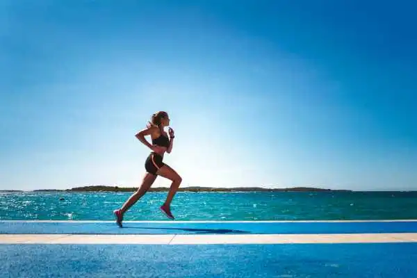Woman running showing strong leg muscle Hampshire